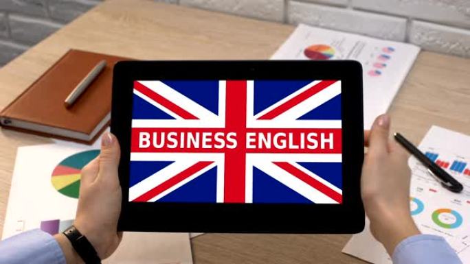 商务英语app against british flag on tablet in female h