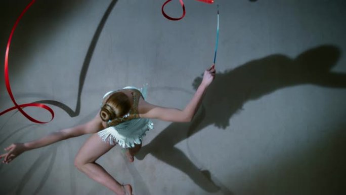 SLO MO LD艺术体操运动员一边优雅地旋转着她的红丝带