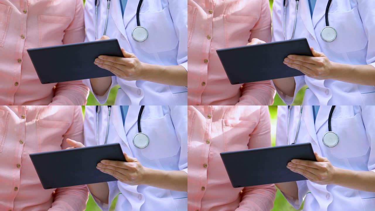 在平板电脑上显示高级女性检查结果的女性治疗师，公园