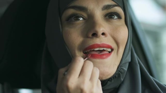 穆斯林妇女使用红色唇膏，明亮的化妆挑战