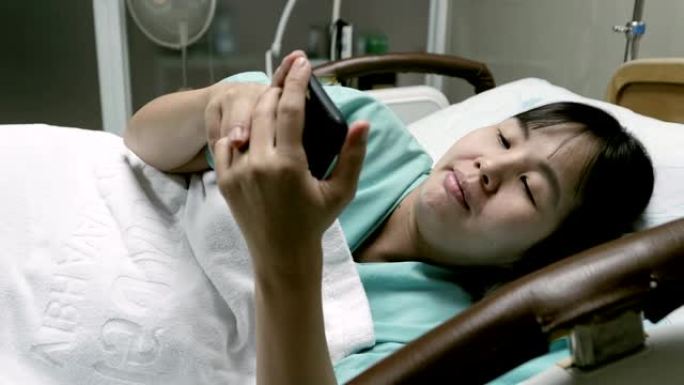 孕妇躺在床上并在医院使用电话