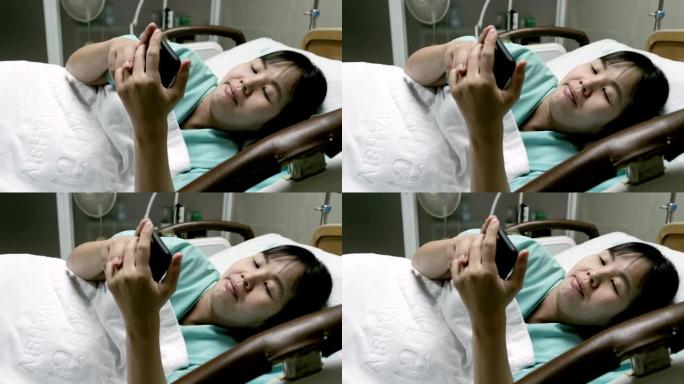 孕妇躺在床上并在医院使用电话