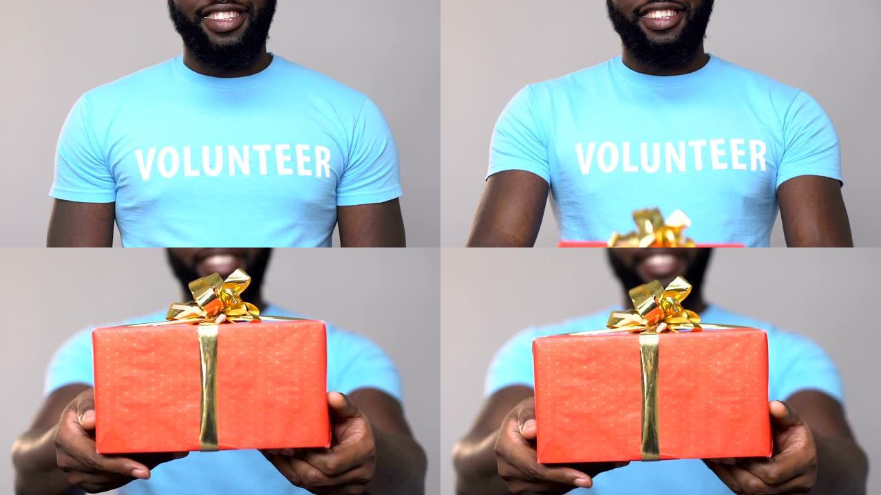 微笑的非洲裔美国志愿者拿着纸板礼盒，援助慈善机构