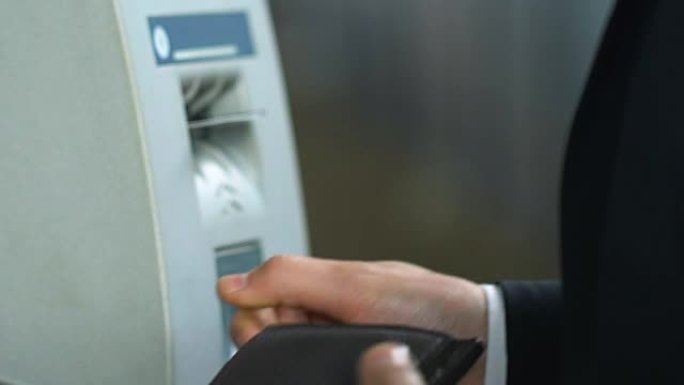 男子在自动取款机中插入信用卡，自动柜员机阅读器出现问题