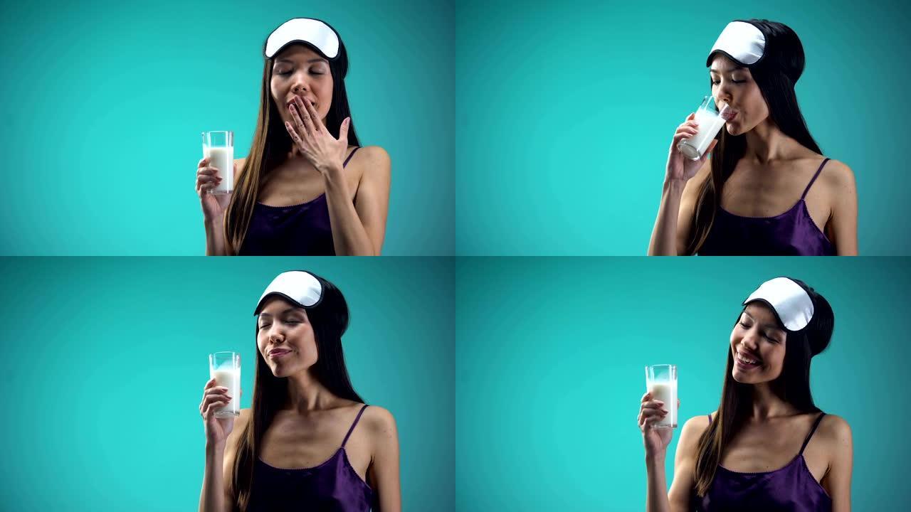微笑的女人喝温暖的牛奶，以改善睡眠，钙和维生素来源
