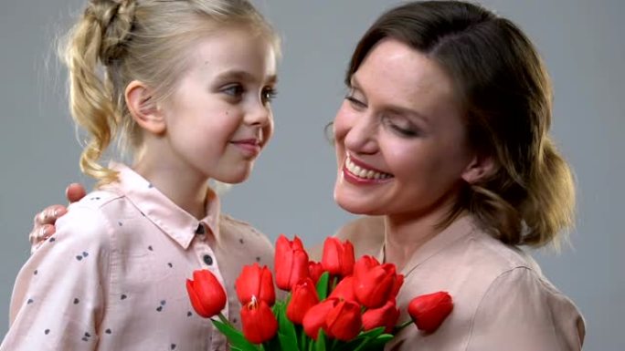 可爱的女孩送花给心爱的母亲，生日或3月8日惊喜