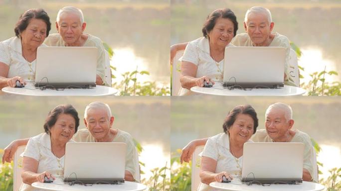 带笔记本电脑的快乐老年夫妇，户外