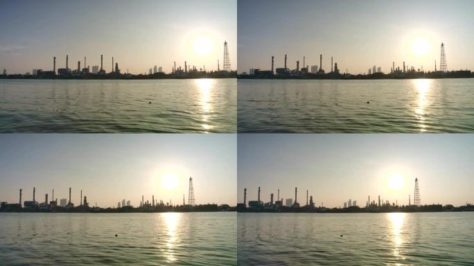 4k分辨率炼油厂在早晨日出时的河边，烟气释放的烟囱的反射轮廓结构