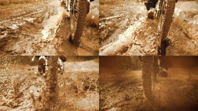 超级慢动作: 追踪骑自行车的人在泥泞中骑行