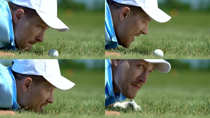 男性高尔夫球手在草地上玩耍，将球吹入洞中，特写镜头