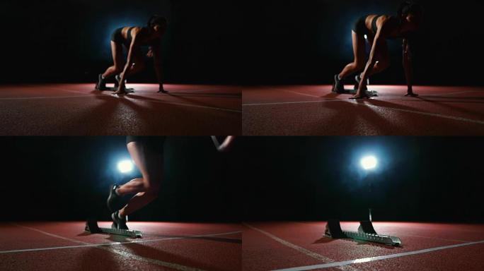 专业女运动员在黑暗的背景下在体育场的跑道上奔跑运动鞋慢跑鞋的冲刺