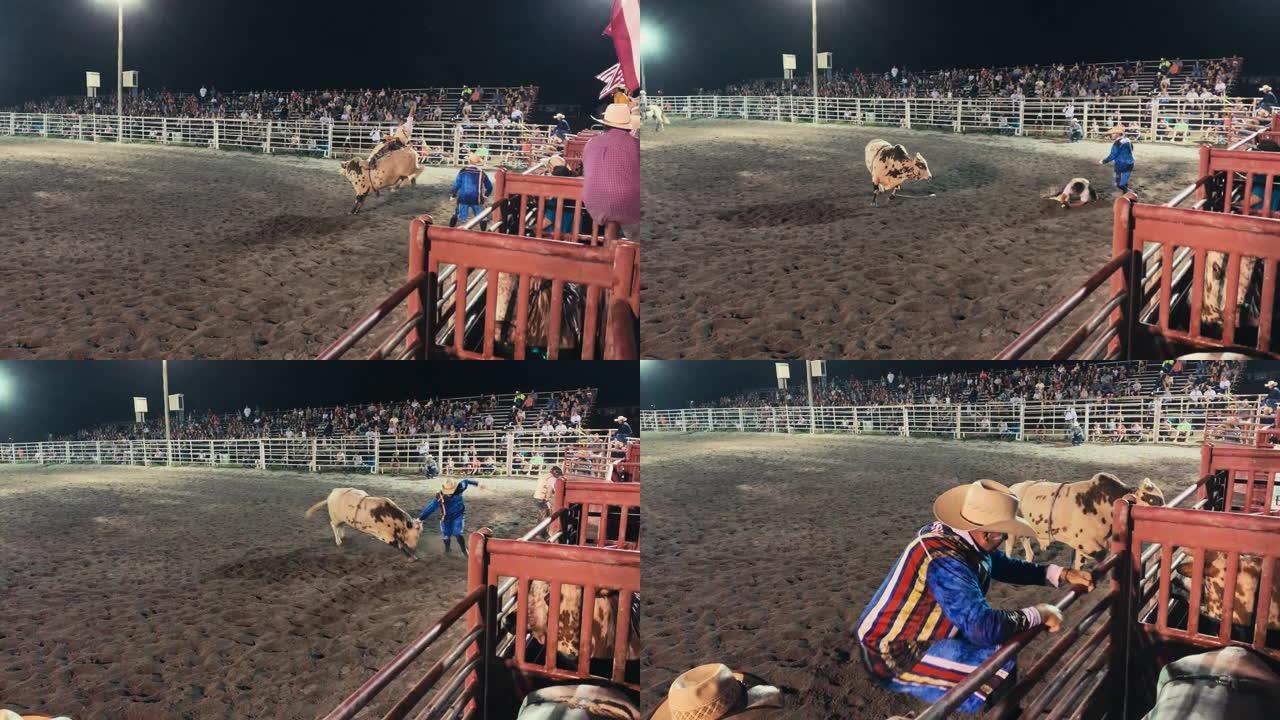 一名公牛骑手参加了一场公牛比赛，然后被从公牛的背上扔了出去，而牛仔竞技小丑在晚上挤满了人的体育场里分