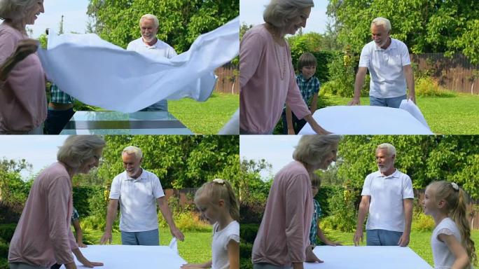 孙辈帮助祖父母用白布摆桌子，度假