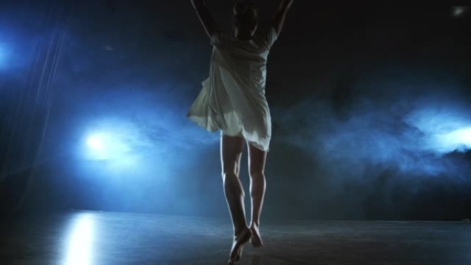 现代芭蕾舞女赤脚做旋转，旋转和舞步，站在舞台上的烟雾慢动作。舞台表演