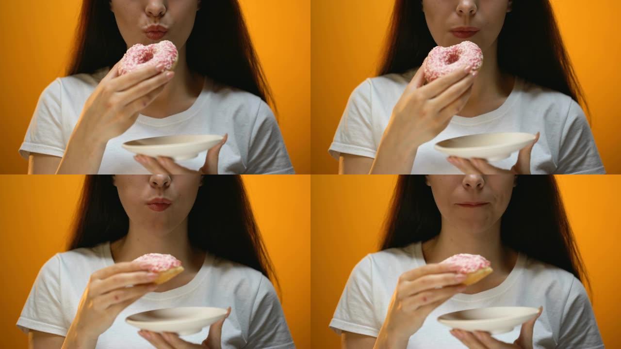 女孩吃甜甜圈，对相机微笑，对甜食上瘾，患糖尿病的风险