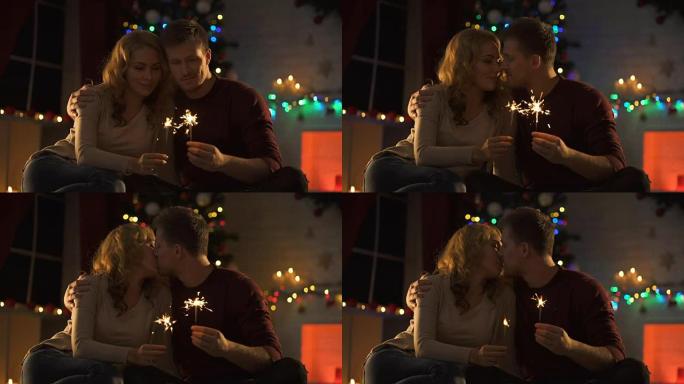 年轻夫妇爱上了闪闪发光的圣诞树附近的孟加拉灯火