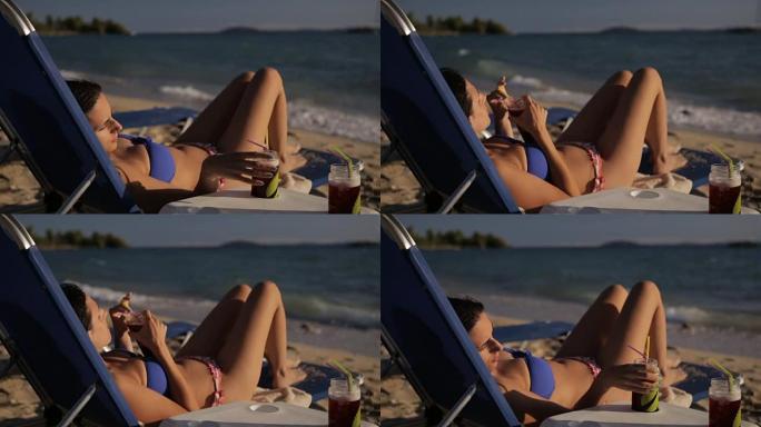 在海滩上喝酒性感美女沙滩躺椅