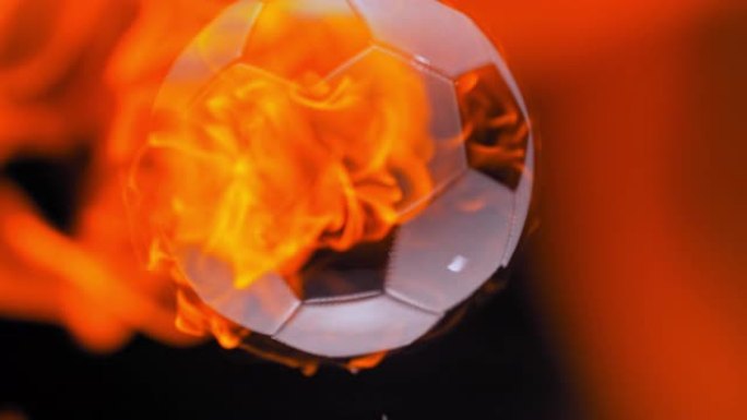 SLO MO LD燃烧的足球在黑色背景下掉入水中