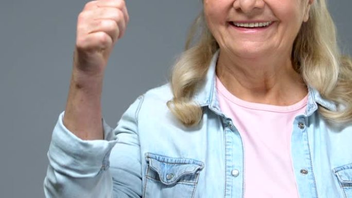 积极的祖母竖起大拇指，心情愉快，赞成手势满意