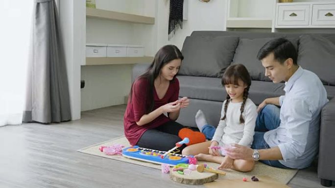 DS父母和女儿在家里的地板上玩玩具