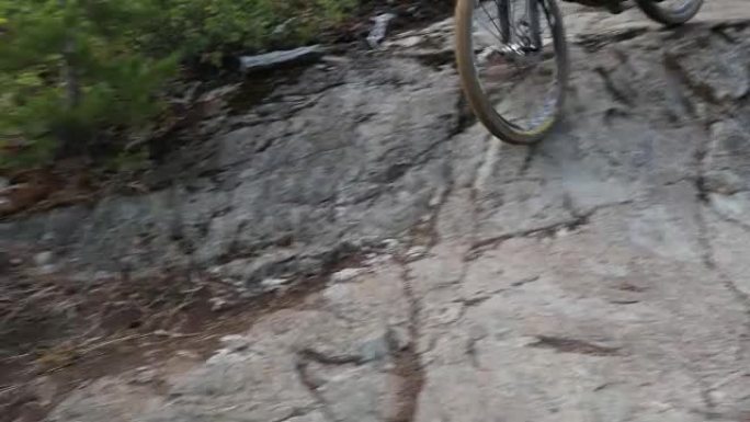 男性山地自行车手下降陡峭的岩板