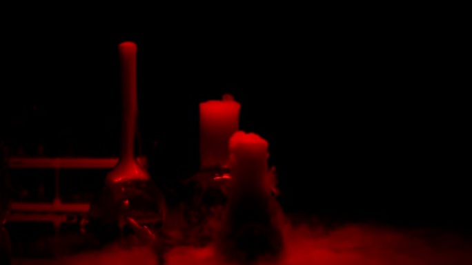 实验室，在红灯下冒泡并冒烟的烧瓶中的化学物质