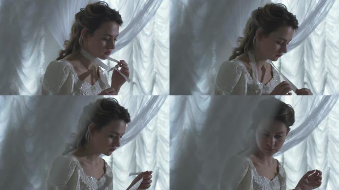 年轻漂亮的女人坐在白色网帘周围，解开脖子上的丝带