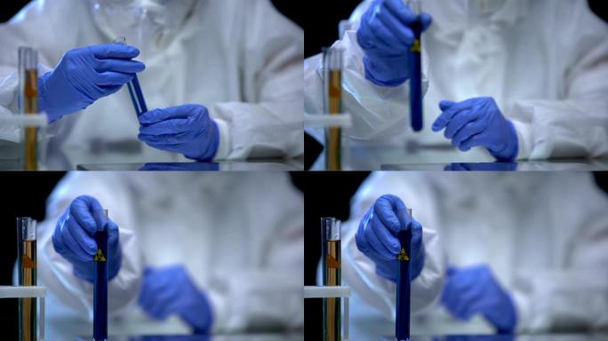有毒的实验室工作人员展示了带有生物危害液体的试管，病毒菌株
