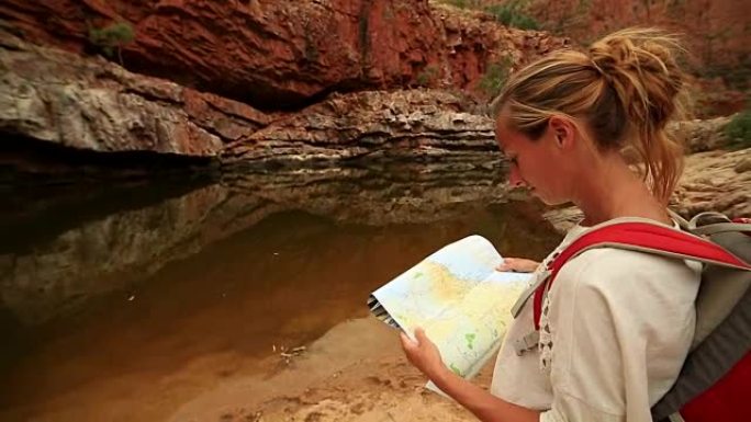 在内陆徒步旅行的女孩阅读地图寻找方向
