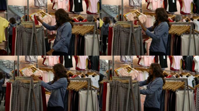 非裔美国美女在服装店看着裤子微笑