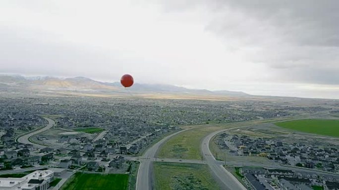 孤独的红色气球漂浮在城市上空
