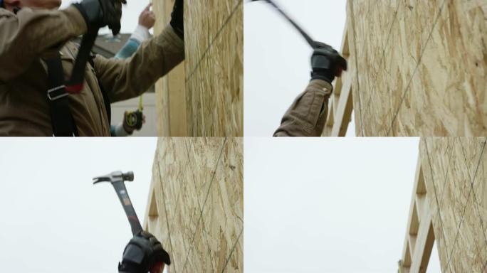 一名四十多岁的拉丁裔男子在冬天阴云密布的天空下，用锤子将一块刨花板固定在建筑工地上。