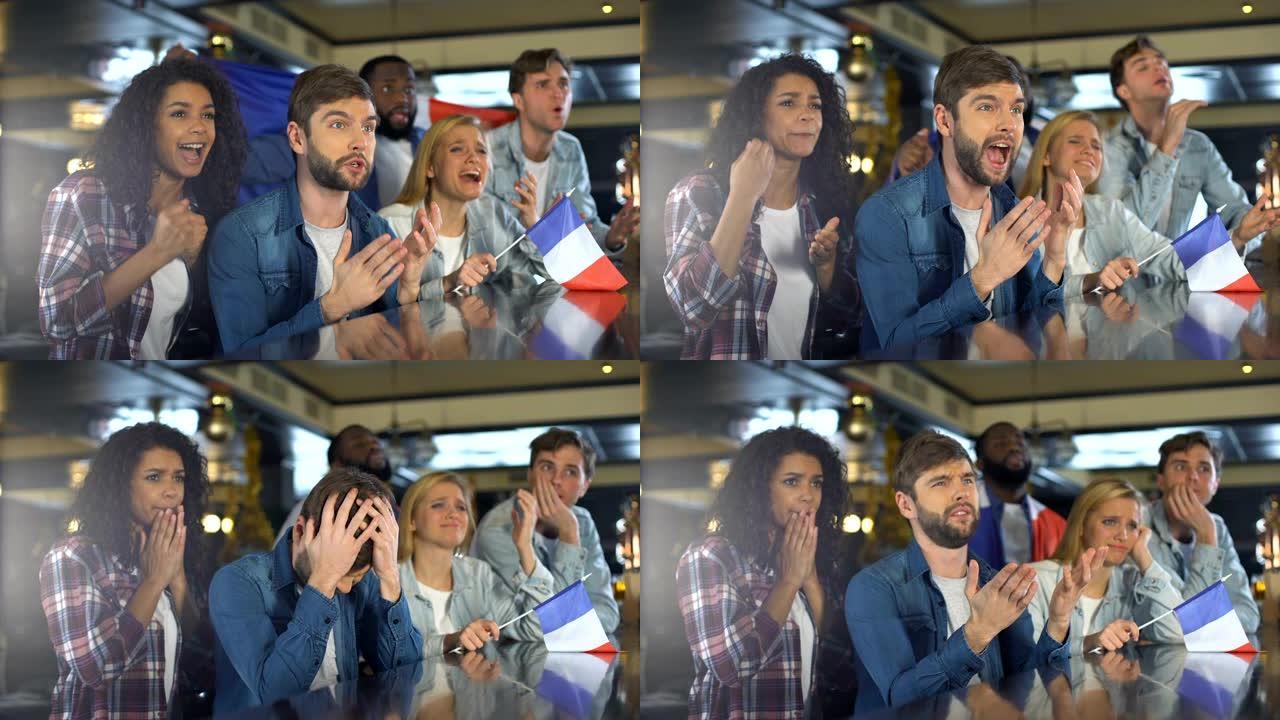 球迷挥舞着法国国旗，在酒吧观看体育节目，对输掉比赛感到不安