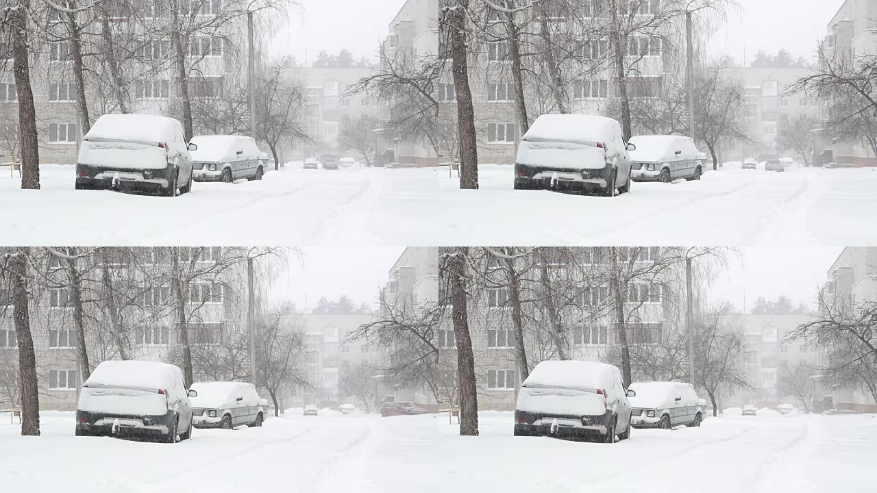 暴风雪和积雪覆盖着停着汽车的街道。