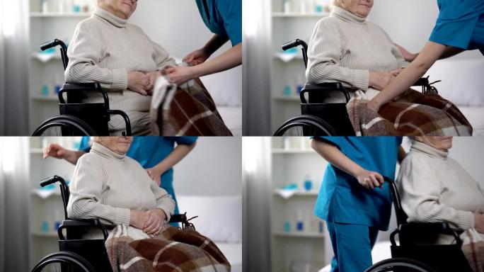 护士用毯子覆盖轮椅上的老妇人，照顾病人