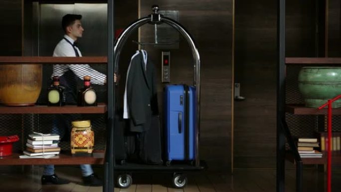拉丁美洲行李员推着行李车穿过酒店的走廊