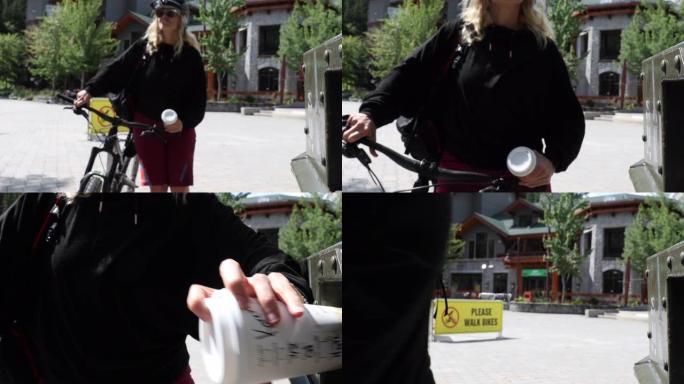 女骑自行车的人将可回收的杯子放在容器中