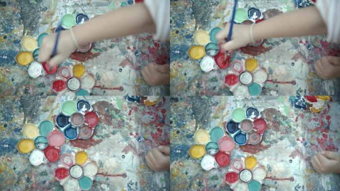 CU: 小女孩在纸上的颜料使用丙烯酸涂料，刷子和调色板。