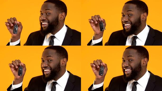 快乐的非裔美国男经理展示汽车钥匙进入相机，租赁服务
