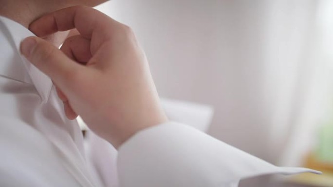 年轻的新娘礼服和衬衫纽扣。婚礼当天快乐的年轻新郎。