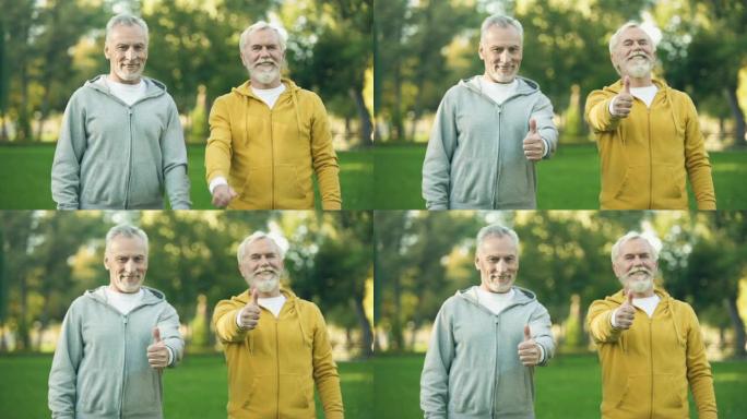 两名穿着运动服的微笑老人表现出竖起大拇指，健康的生活方式