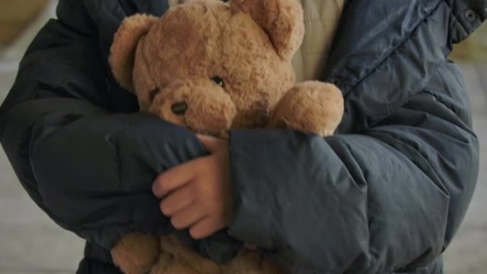 无家可归女孩手握泰迪熊的特写镜头