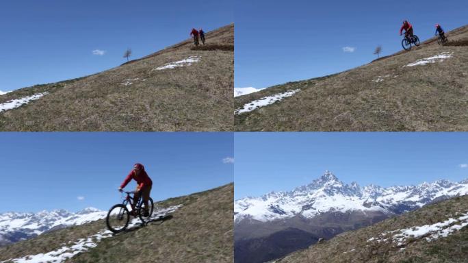 山地车手通过雪下降山坡