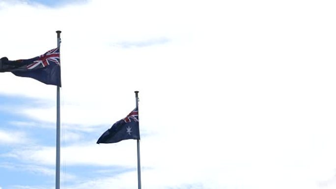 一面澳大利亚国旗在风中飘扬飘扬，天空蔚蓝。