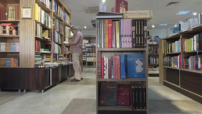 资深男子从图书馆书架上拿书