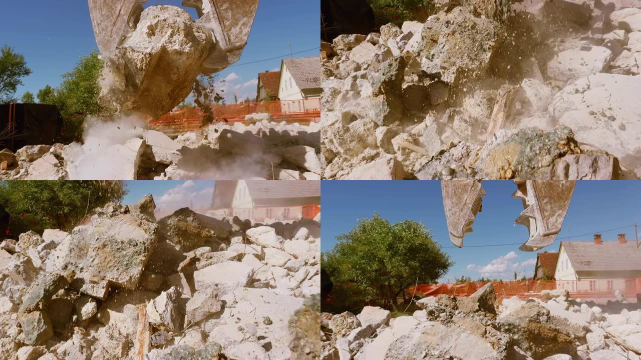挖掘机抓斗在阳光下压碎一块混凝土，形成建筑碎片