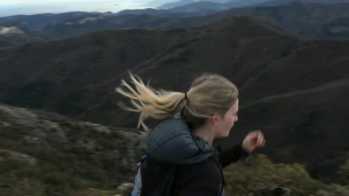 女越野跑运动员登上山脊