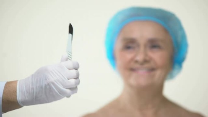 衰老的女士害怕用柳叶刀的手，对手术治疗持消极态度