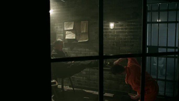 男囚犯在监狱通过窗户清理桌子