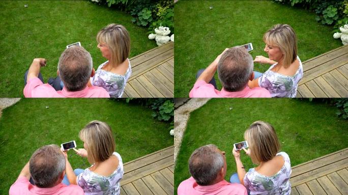 夫妇在智能手机上看着他们的照片